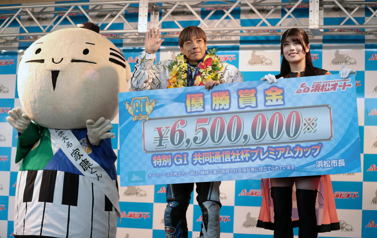 優勝した青山周平は浜松オートレースヴィーナスYOSHINOと賞金ボードを持つ（撮影・柴田隆二）