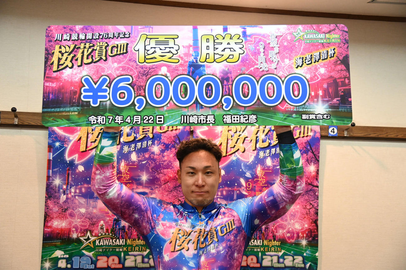 優勝した郡司浩平は賞金ボードを掲げる