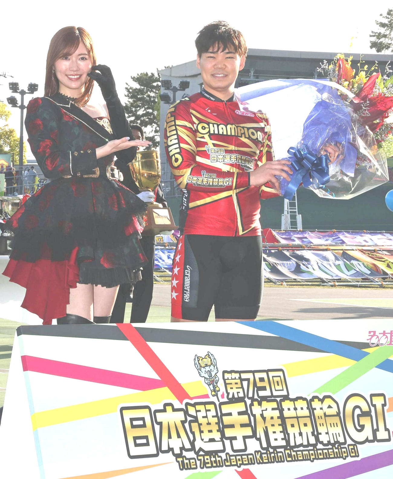 日本選手権イメージキャラクターの松井珠理奈（左）から花束を受け取る吉田拓矢