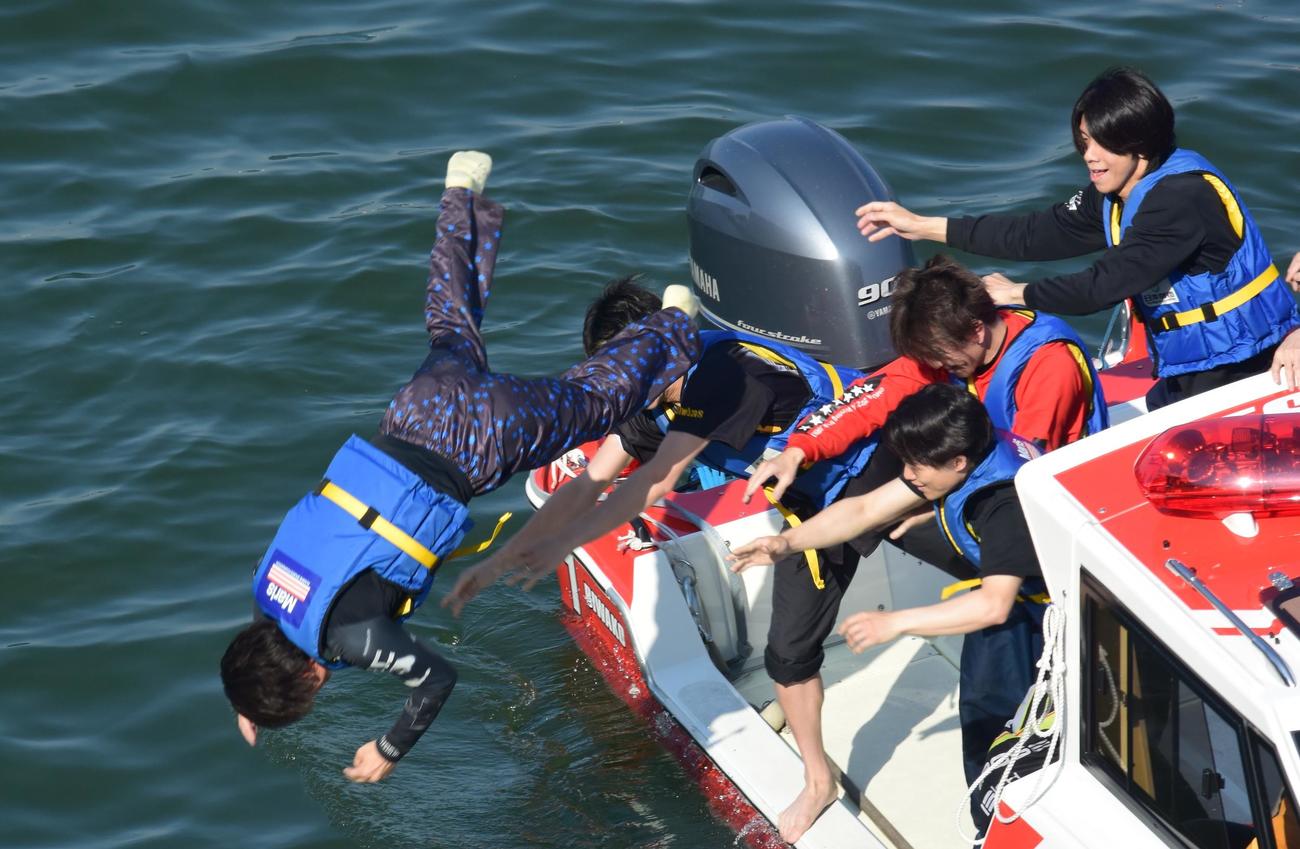 通算1500勝を達成した深井利寿（左）が、水神祭で水面に放り投げられた