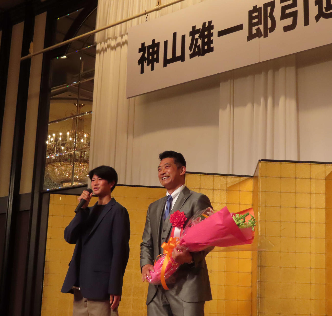 神山雄一郎氏（右）が息子の煌士郎さんより花束贈呈と感謝の思いを聞いて表情を崩す（撮影・野島成浩）