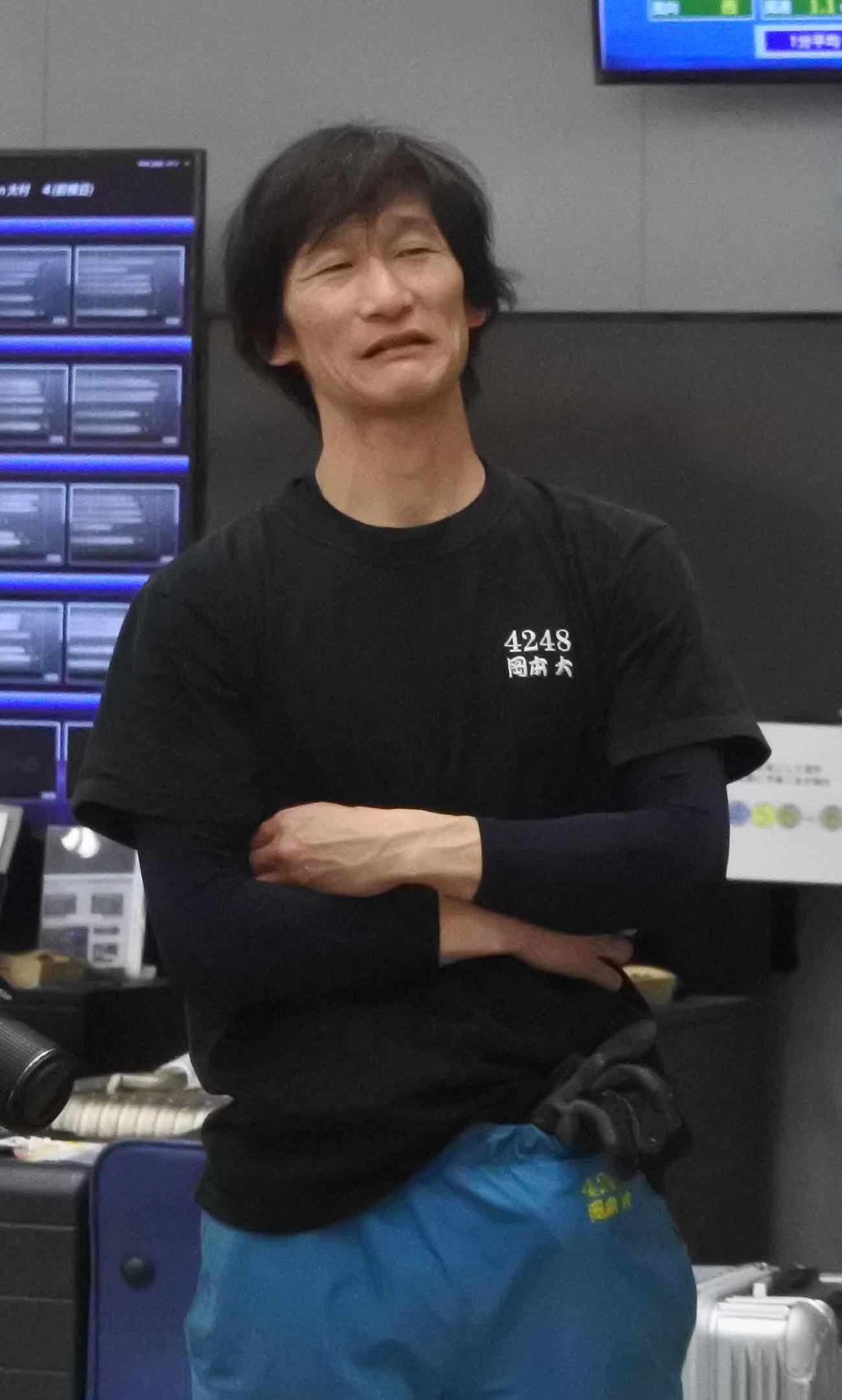 腕を組み、調整を思案する岡本大