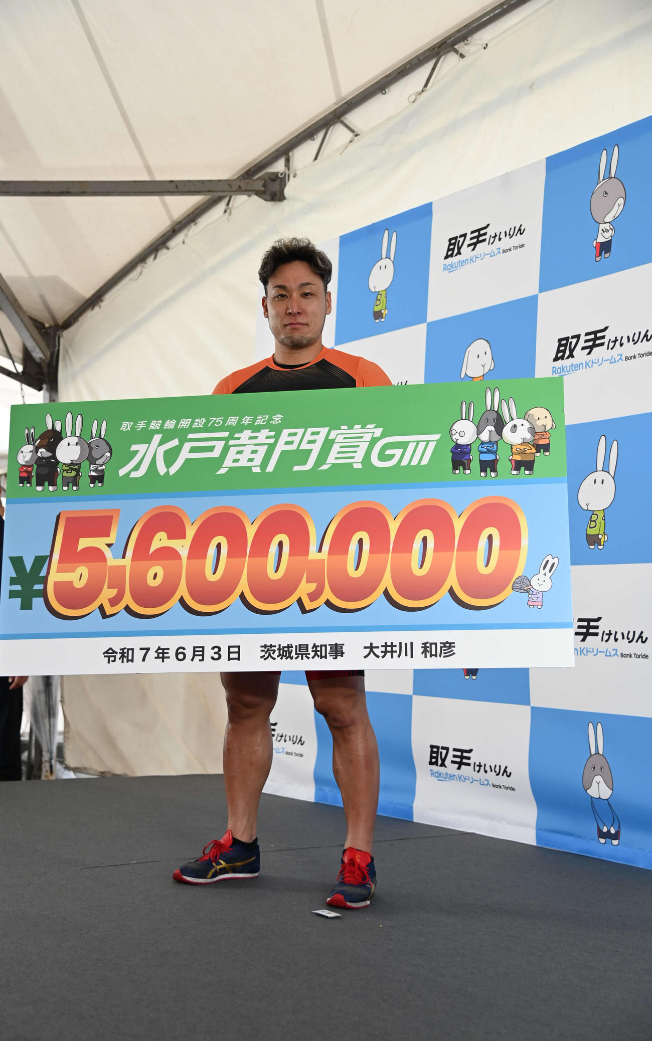 集まったファンの前で賞金ボードを披露する郡司浩平