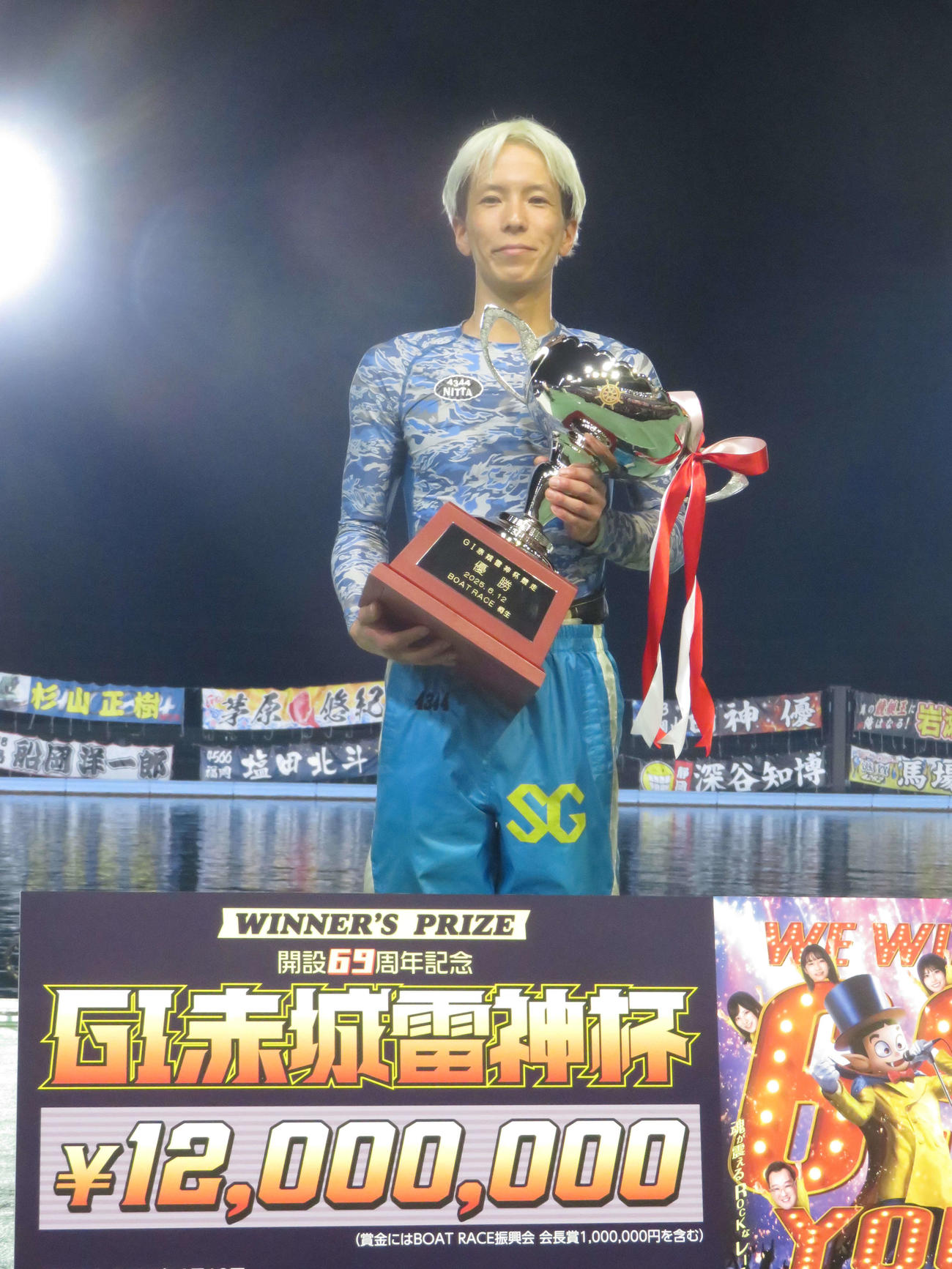 優勝トロフィーを手に笑顔を見せる新田雄史