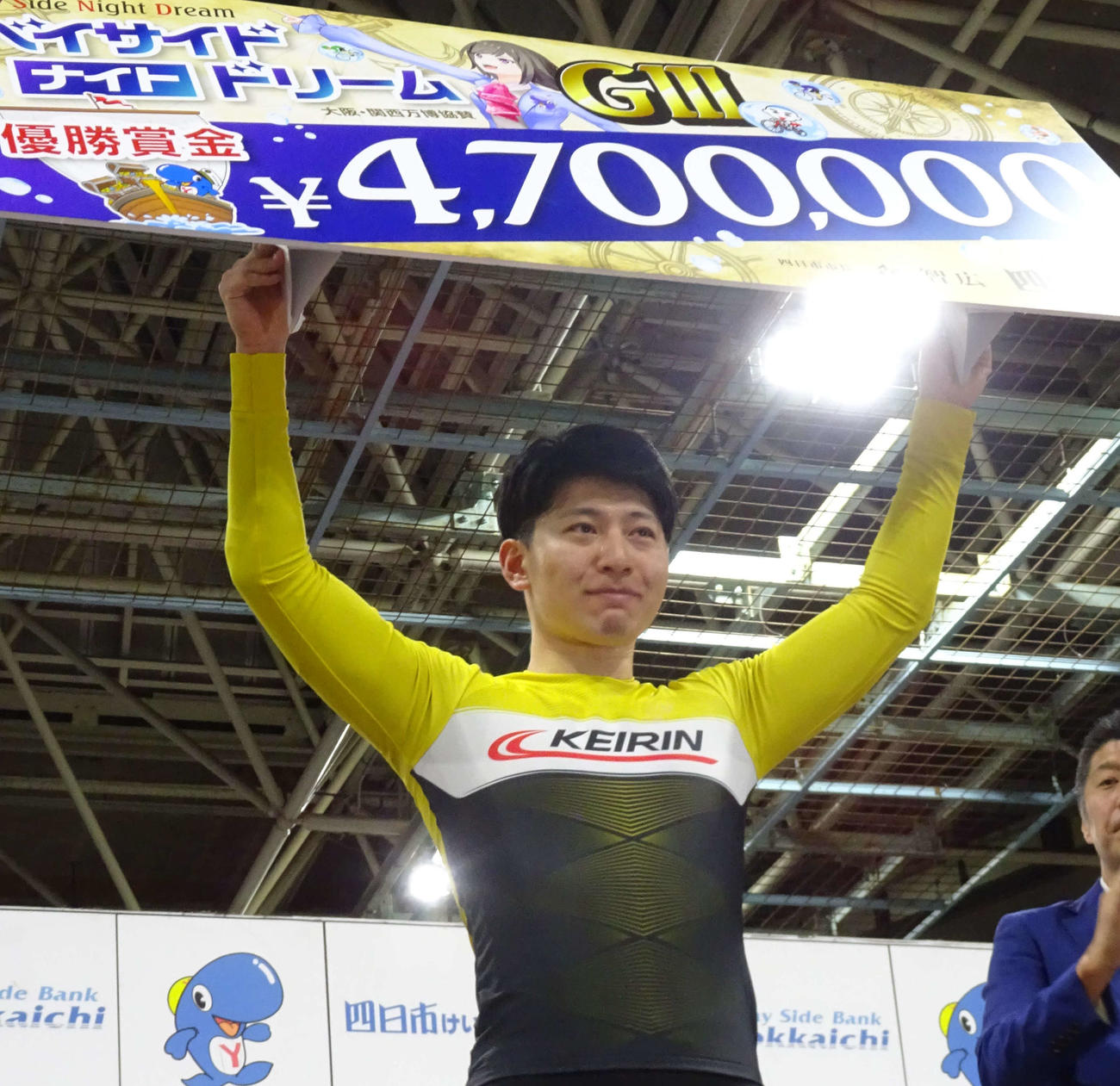 優勝し賞金ボードを掲げる簗田一輝