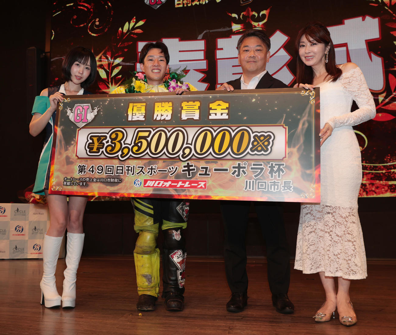 優勝した黒川京介（左から2人目）は賞金ボードを掲げる。左から川口オートレースイメージガール夜道雪、1人置いて粕谷卓至コンテンツ本部長、矢部美穂（撮影・柴田隆二）