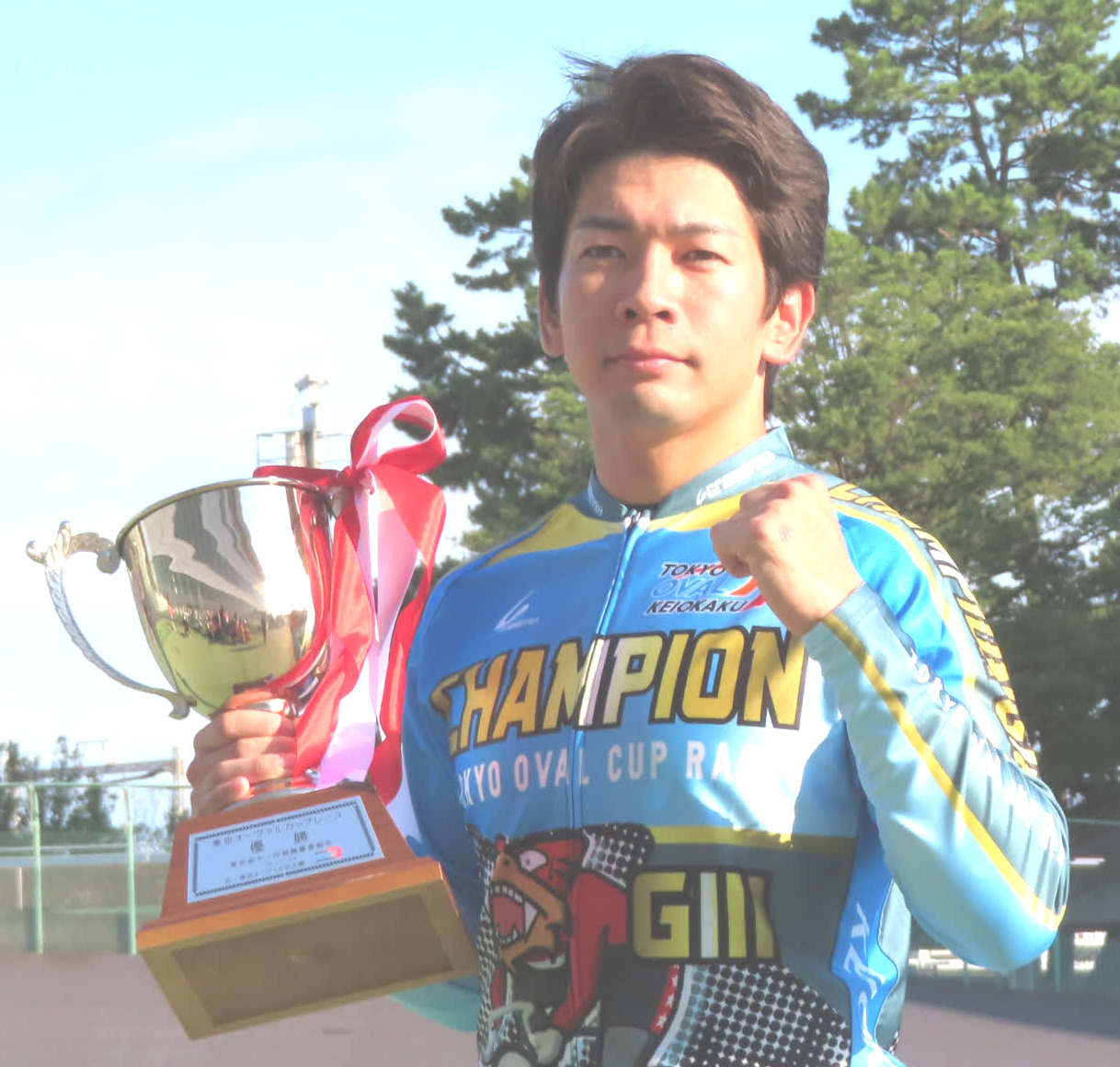 優勝カップを手にガッツポーズする鈴木竜士