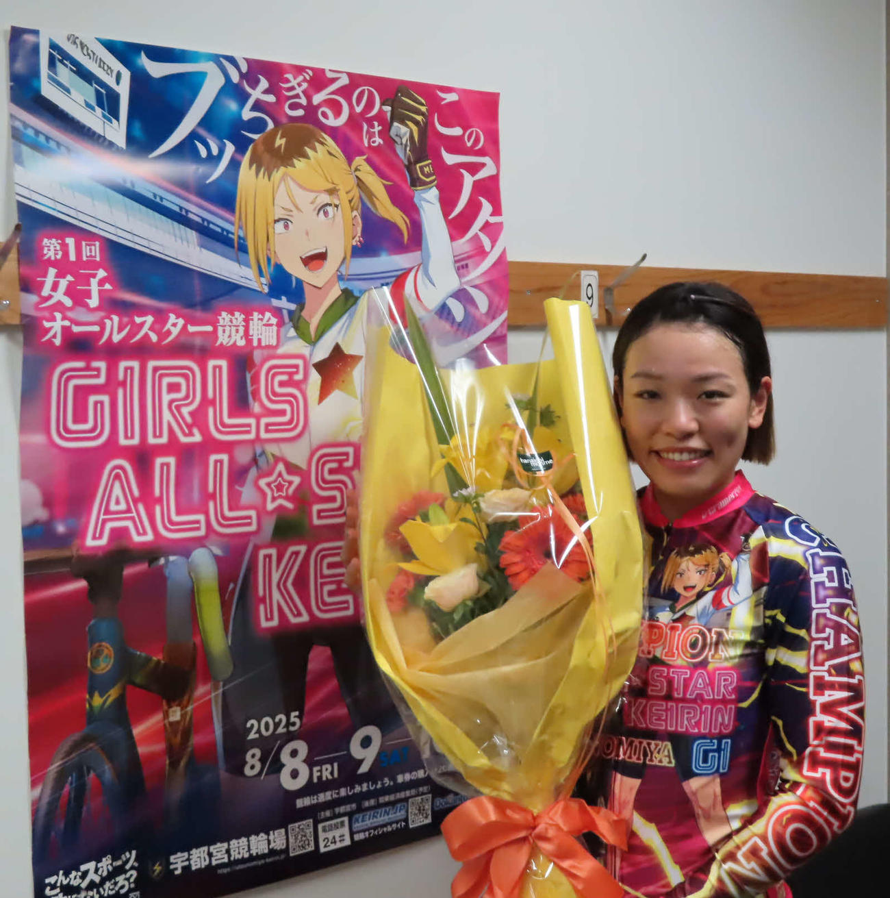佐藤水菜が大会ポスターをバックに記念撮影に応じる（撮影・野島成浩）