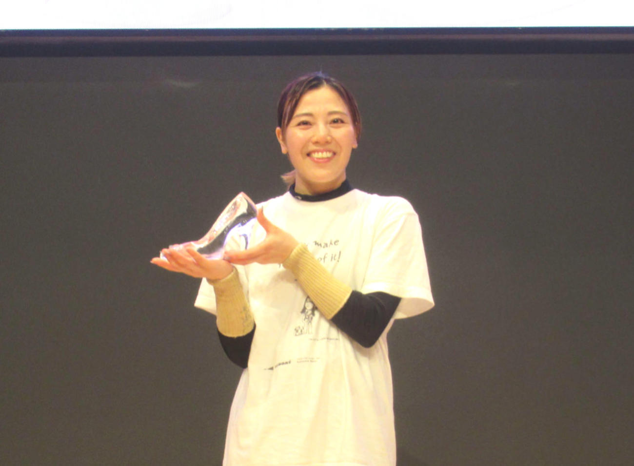 ガラスの靴のトロフィーを手に笑顔の中田夕貴