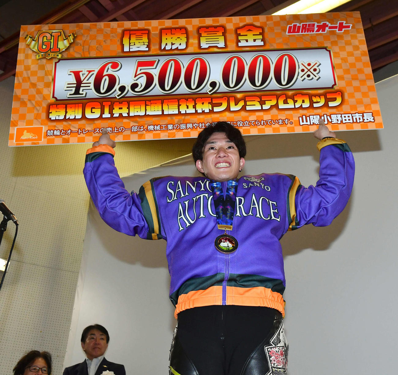 優勝した黒川京介は笑顔で賞金ボードを掲げる（撮影・岩下翔太）