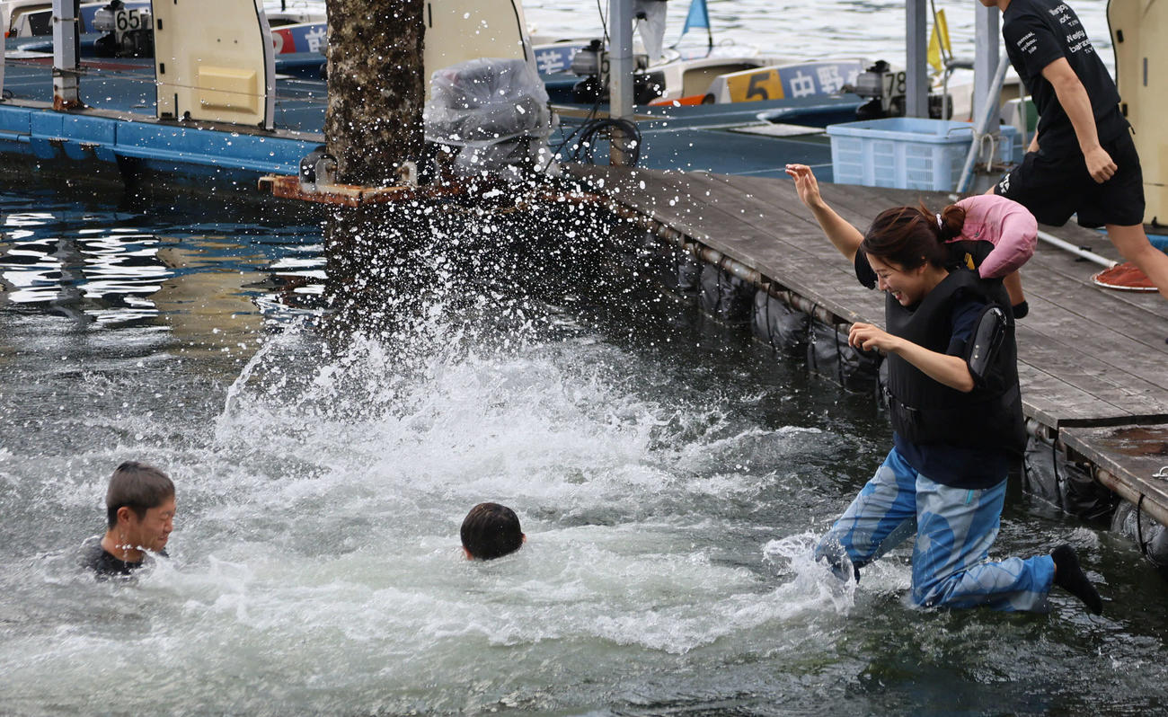 宮島ボートG1ヤングダービー　7RでG1初勝利の4991宗行治哉の水神祭で飛び込む4963実森美祐（右）（撮影・西尾就之）＝宮島ボート場、2025年9月24日
