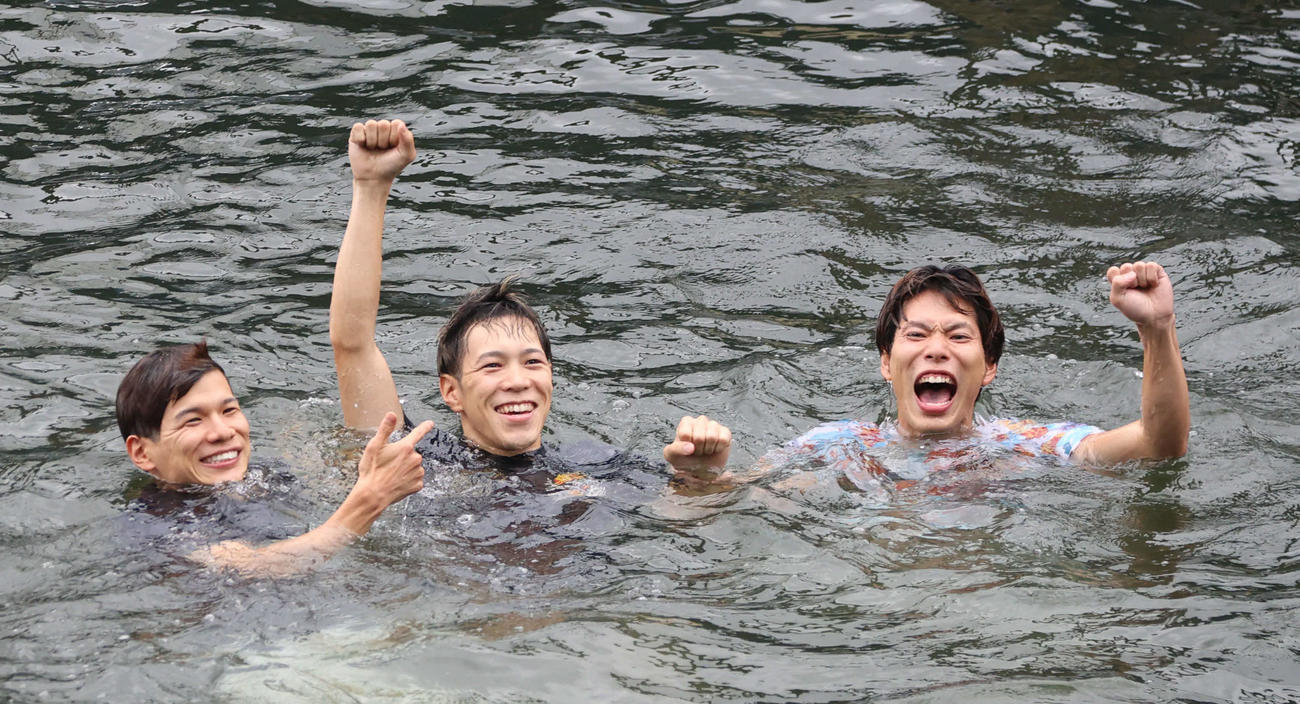 登玉隼百（中）は水神祭で水面に投げ込まれポーズをとる（撮影・西尾就之）