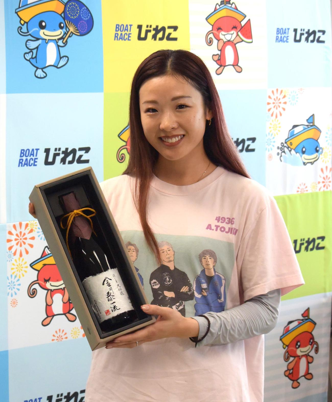 優勝した戸敷晃美が、副賞の大吟醸酒を手に笑顔