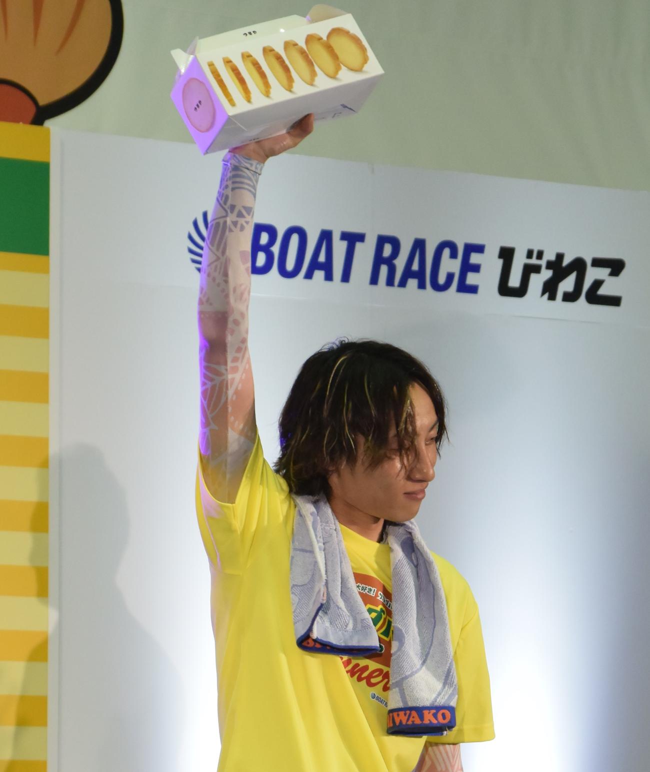 優勝した豊田健士郎が、副賞の「まるい食パンラスク」を受け取り、高く掲げた