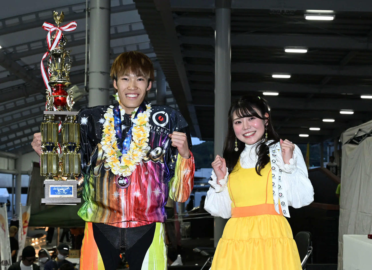 笑顔でガッツポーズする佐藤励（左）と「飯塚オート6代目勝利の女神」KAREN（撮影・林敢治）