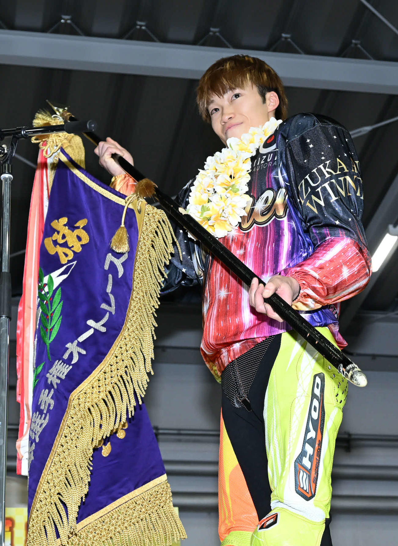 優勝旗を手に笑顔を見せる佐藤励（撮影・林敢治）
