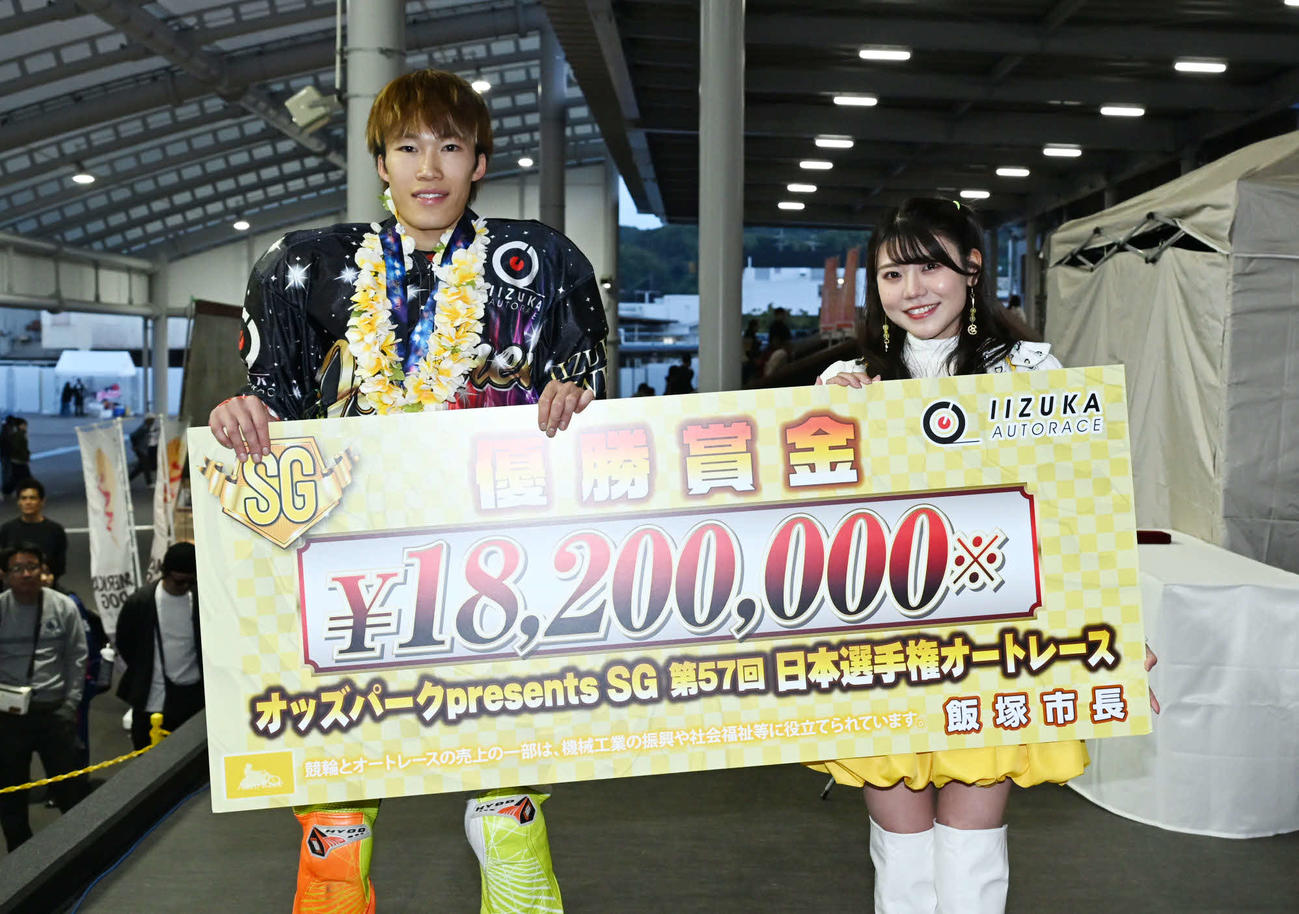 賞金ボートを手に笑顔を見せる佐藤励（左）と「飯塚オート6代目勝利の女神」KAREN（撮影・林敢治）