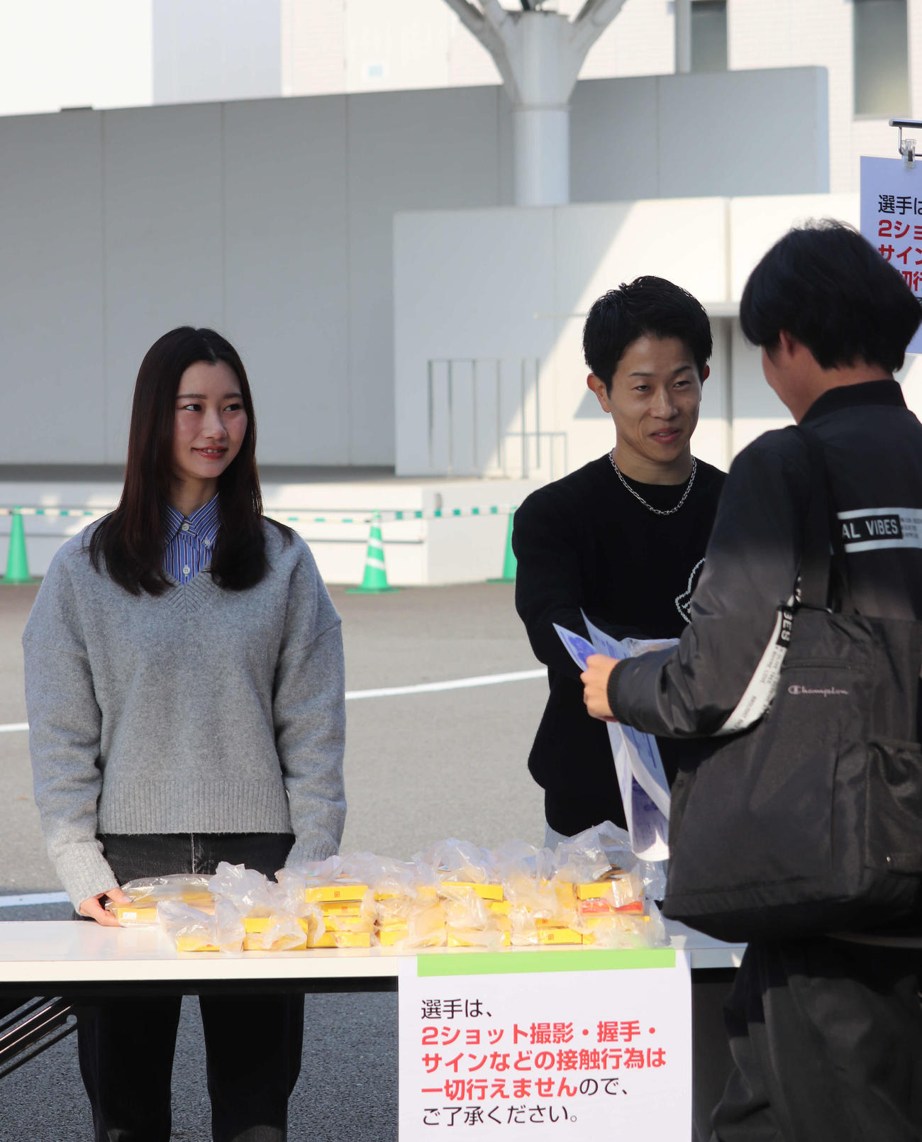 尼崎ボート再開を記念して武井莉里佳（左）と山下大輝が出迎え＆先着プレゼントを渡した（撮影・神田成史）