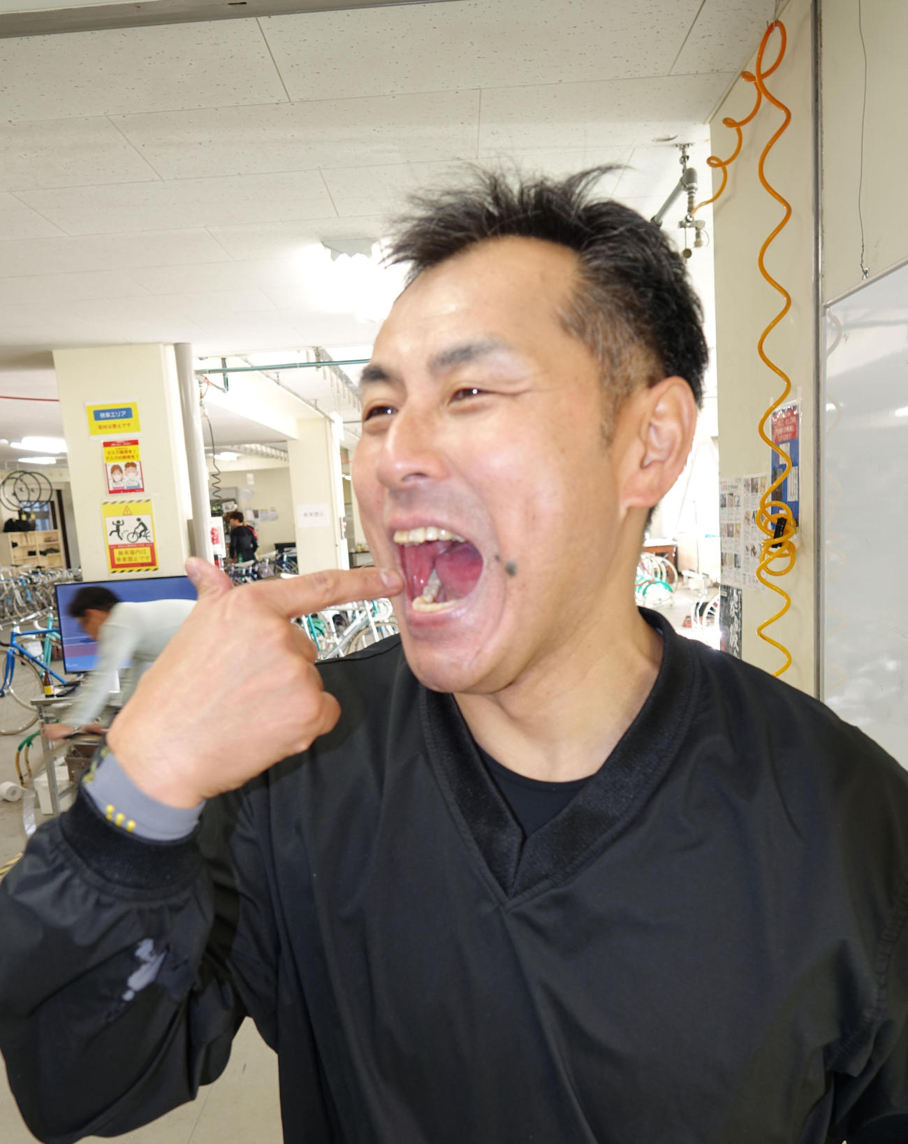 口を開けて治療した歯を指さす高谷雅彦