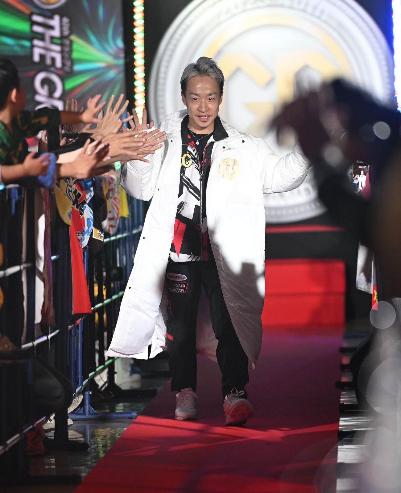 ファンとハイタッチしながら入場する山口剛（撮影・和賀正仁）