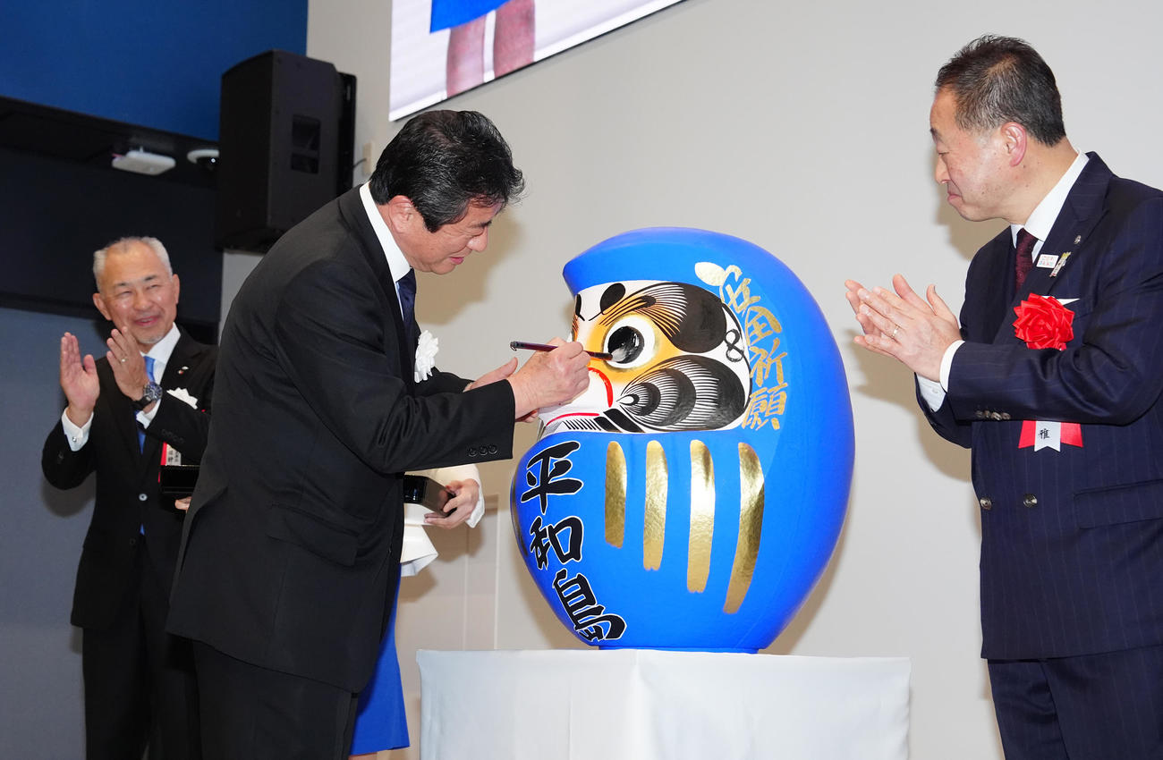 ボートレース平和島新スタンド棟1期の落成式でだるまに目入れする府中市の高野律雄市長（中央）（撮影・江口和貴）