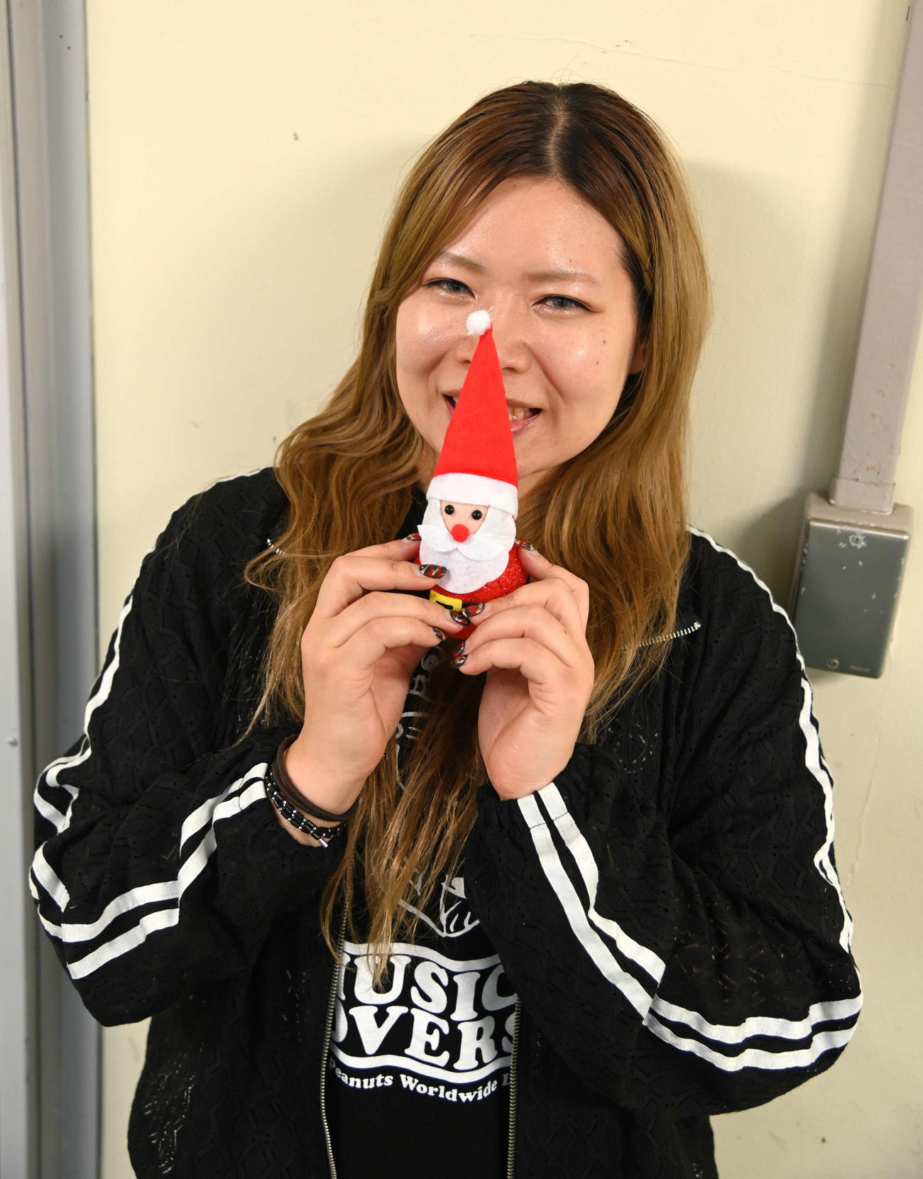 石井寛子はサンタの人形を手に笑顔を見せる