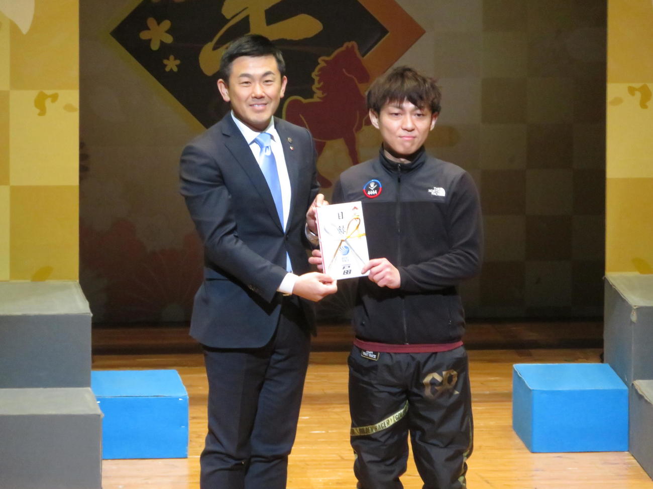 戸田市の菅原文仁市長（左）に目録を手渡す桐生順平