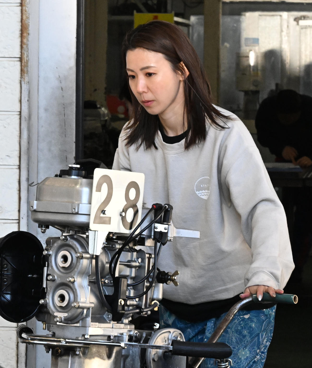 ヴィーナスシリーズ第19戦是政プリンセスカップ前検日、エンジンをボートに移動する鎌倉（撮影・千葉一成）