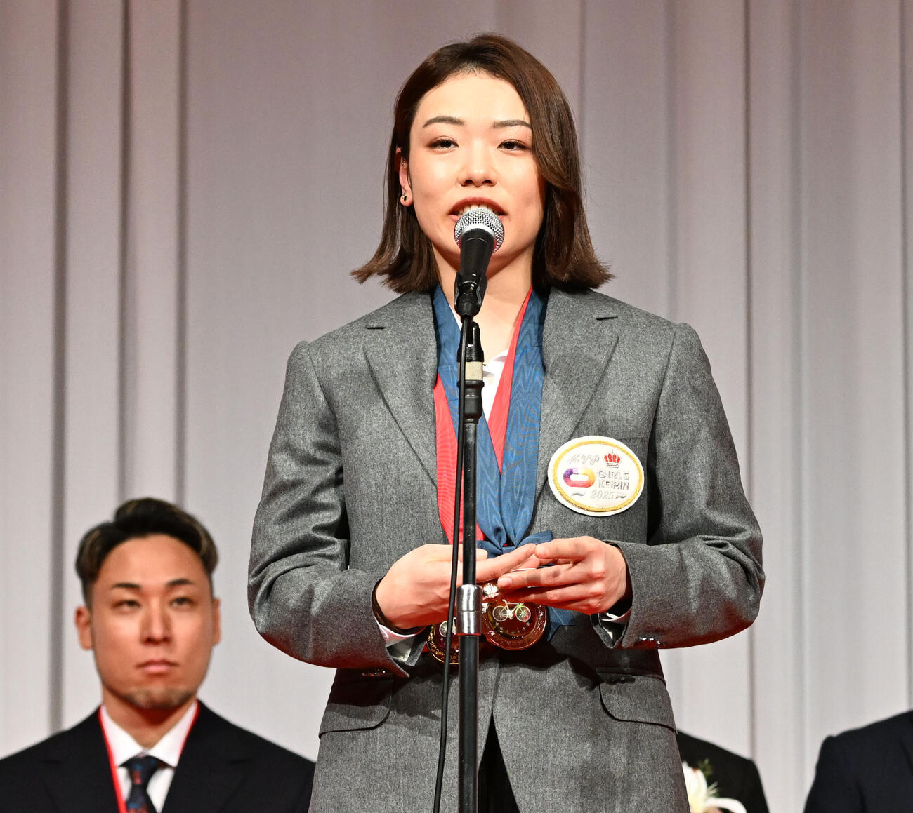 競輪の2025年優秀選手表彰式で、最優秀選手賞を受賞し、あいさつする佐藤水菜。左は郡司浩平（撮影・千葉一成）