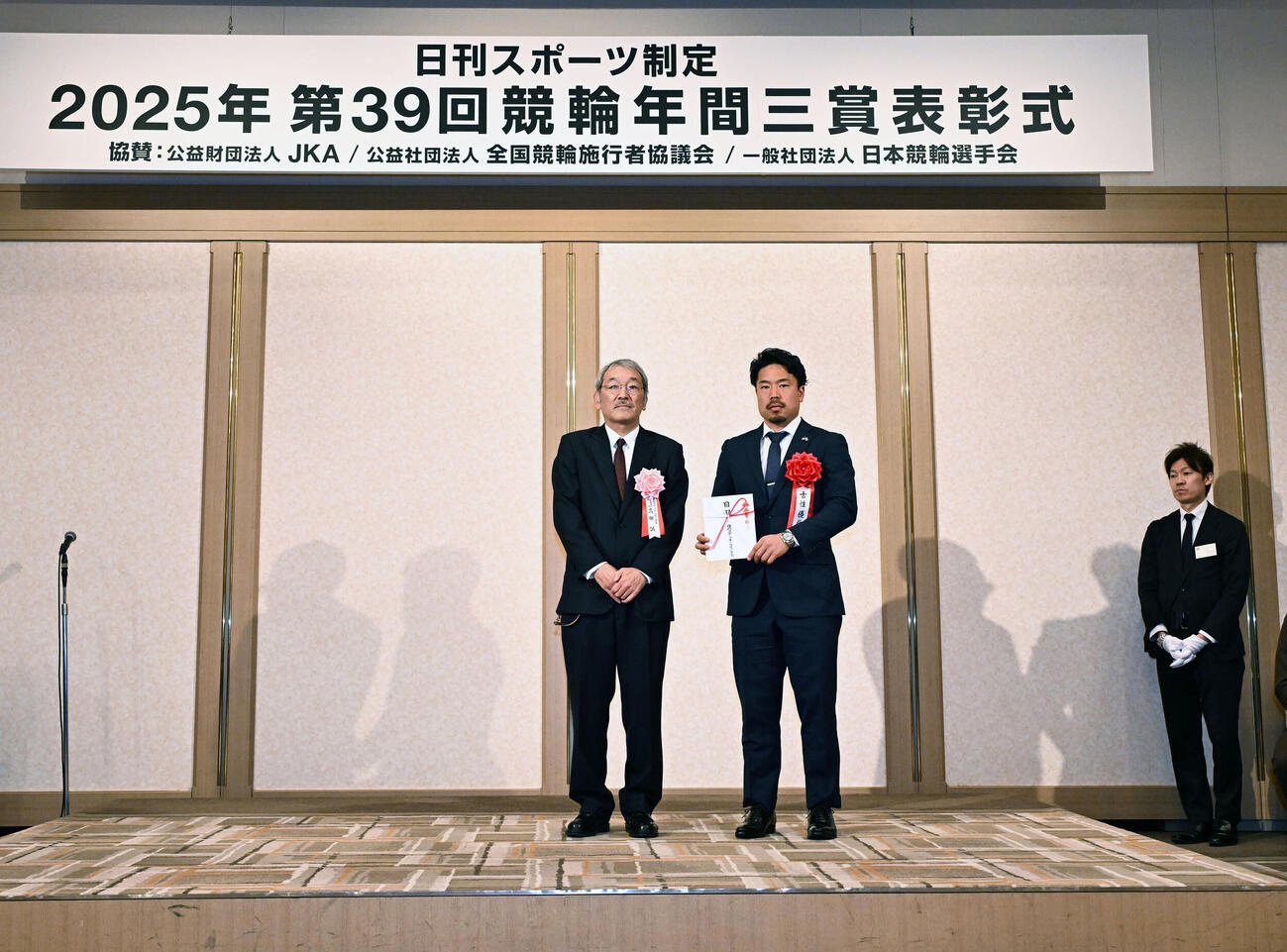 日刊スポーツ制定2025年第39回競輪年間三賞表彰式　技能賞を受賞し、日刊スポーツの高田社長（左）と記念写真に納まる古性（撮影・千葉一成）