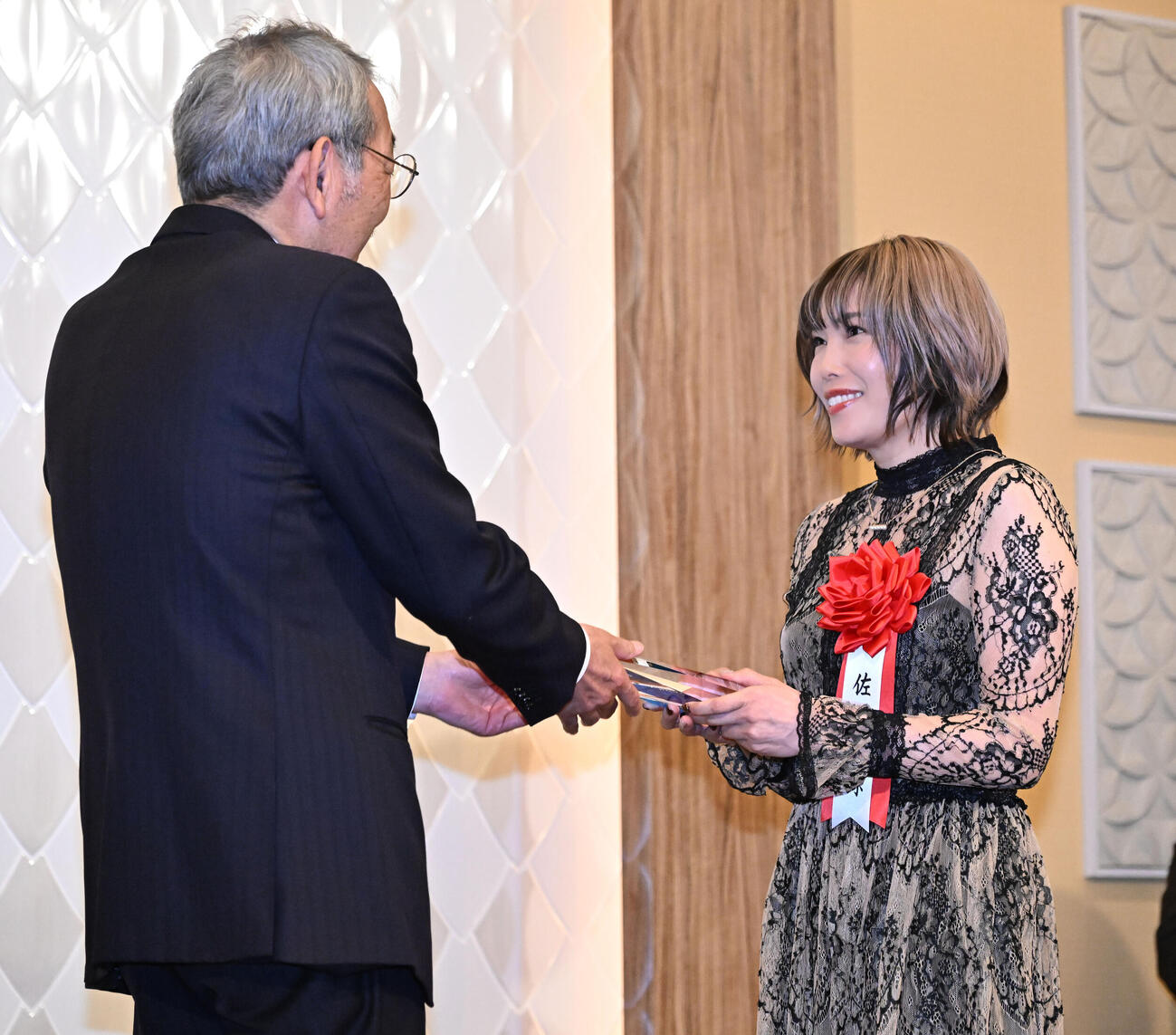 第38回オートレース年間三賞表彰式で、日刊スポーツホールディングスの高田社長（左）から記念の盾を贈られる女子特別賞を受賞した佐藤摩弥（撮影・千葉一成）