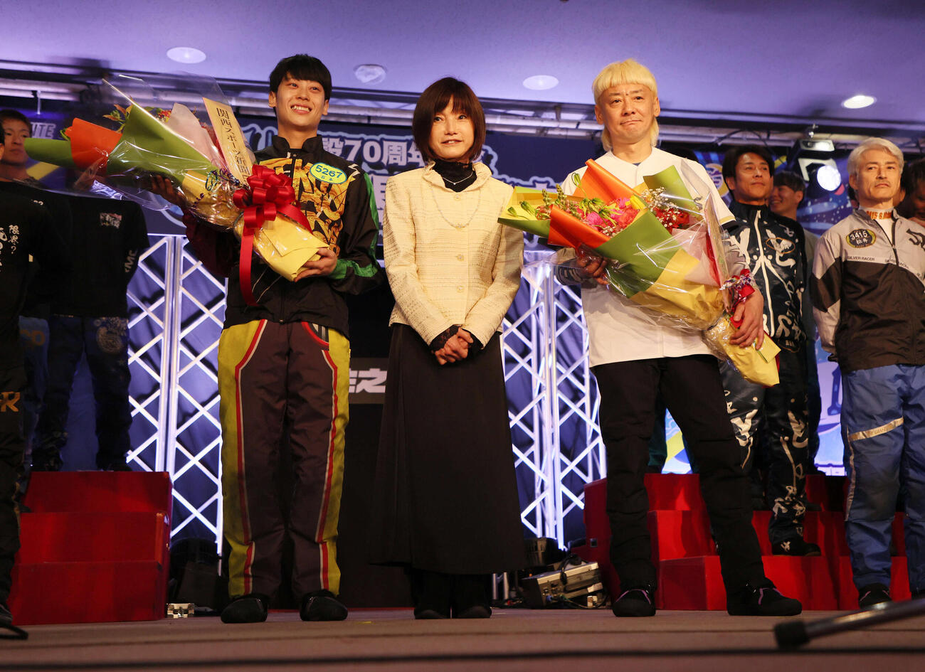 住之江G1太閤賞の開会式で花束を受け取った石本裕武（左）と湯川浩司。中央はプレゼンターで元レーサーの日高逸子さん（撮影・宮崎幸一）