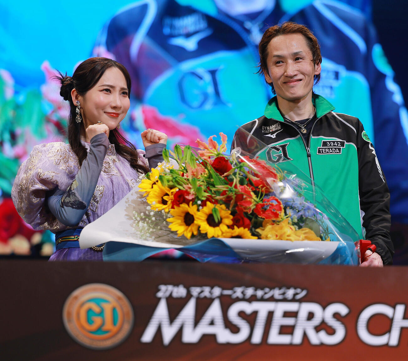 優勝を飾り、プレゼンターのファーストサマーウイカ（左）から花束を受け取る白井英治（撮影・上山淳一）