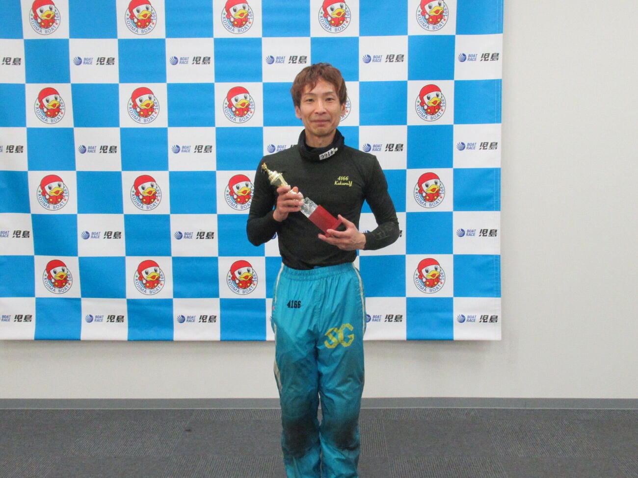 優勝トロフィーを手にほほえむ吉田拡郎