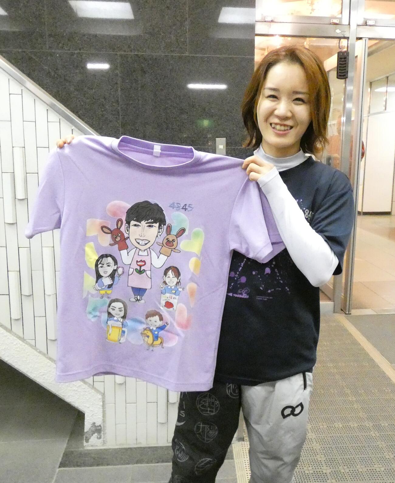 似顔絵Tシャツを持つ前田紗希