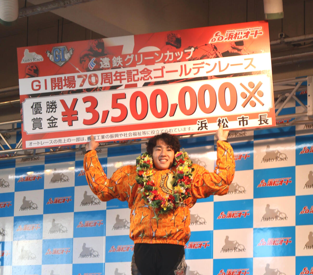 笑顔で賞金ボードを掲げる黒川京介