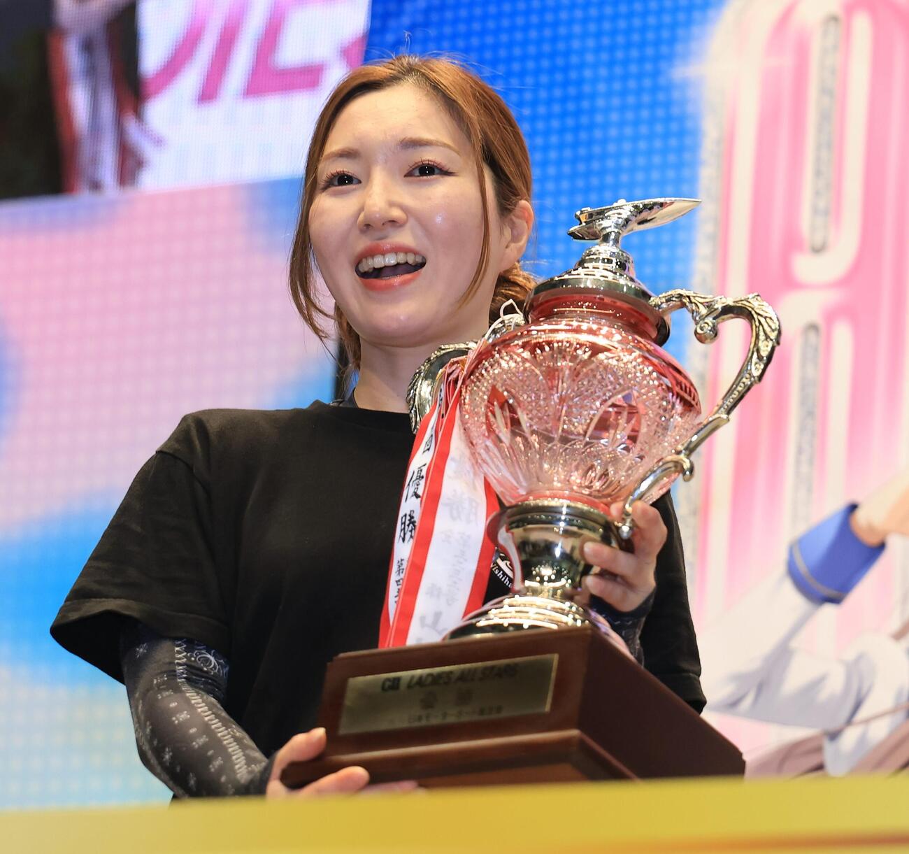 笑顔で優勝トロフィーを掲げる西橋奈未