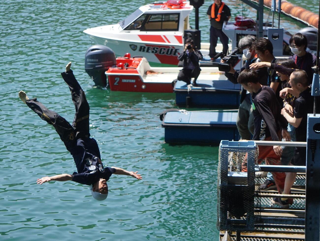 平田忠則（左）は水神祭のセレモニーで水面にダイブ