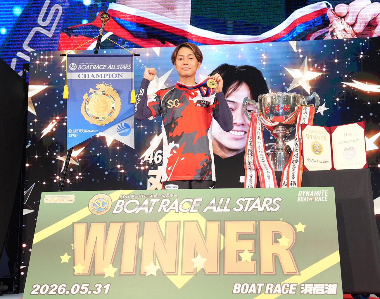 優勝しメダルを手に笑顔で記念撮影に応じる丸野一樹