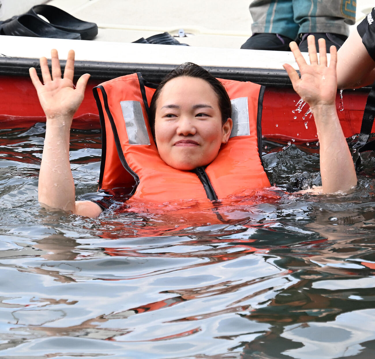 初勝利を挙げ、仲間から水に落とされる手荒い祝福を受け水面からファンの歓声に応える原村百那（撮影・千葉一成）