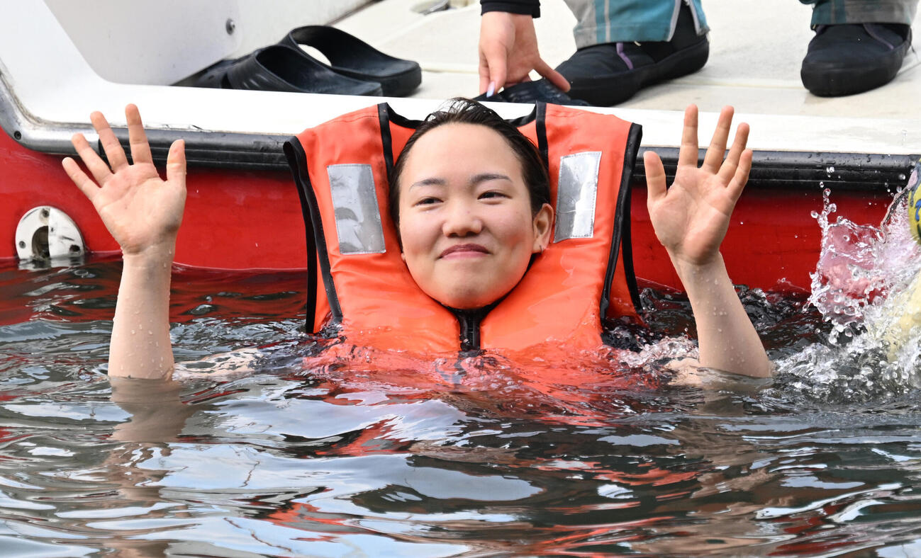 初勝利を挙げ、仲間から水に落とされる手荒い祝福を受け水面からファンの歓声に応える原村百那（撮影・千葉一成）
