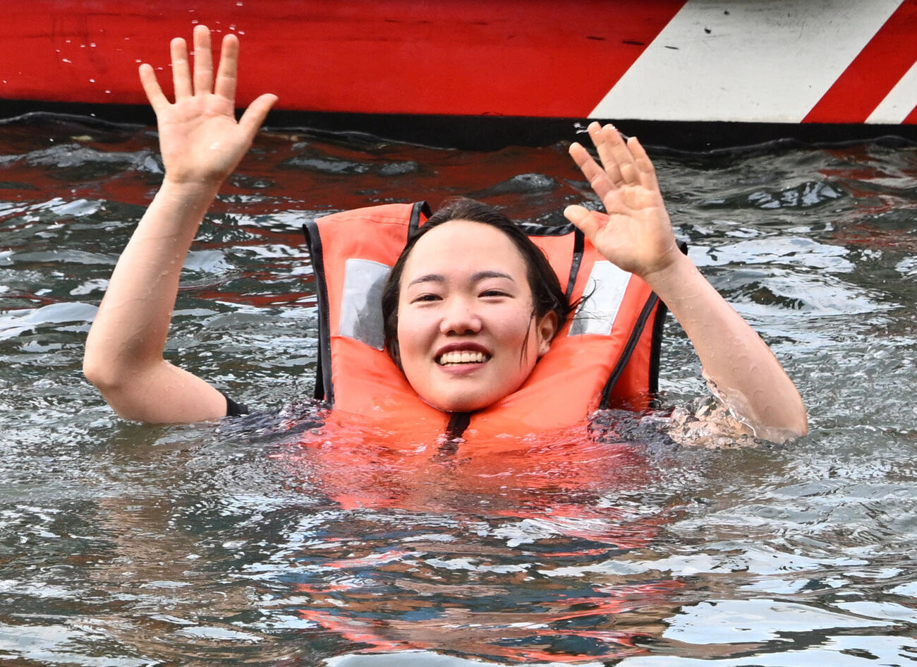 初勝利を挙げ、仲間から水に落とされる手荒い祝福を受け水面からファンの歓声に応える原村百那（撮影・千葉一成）