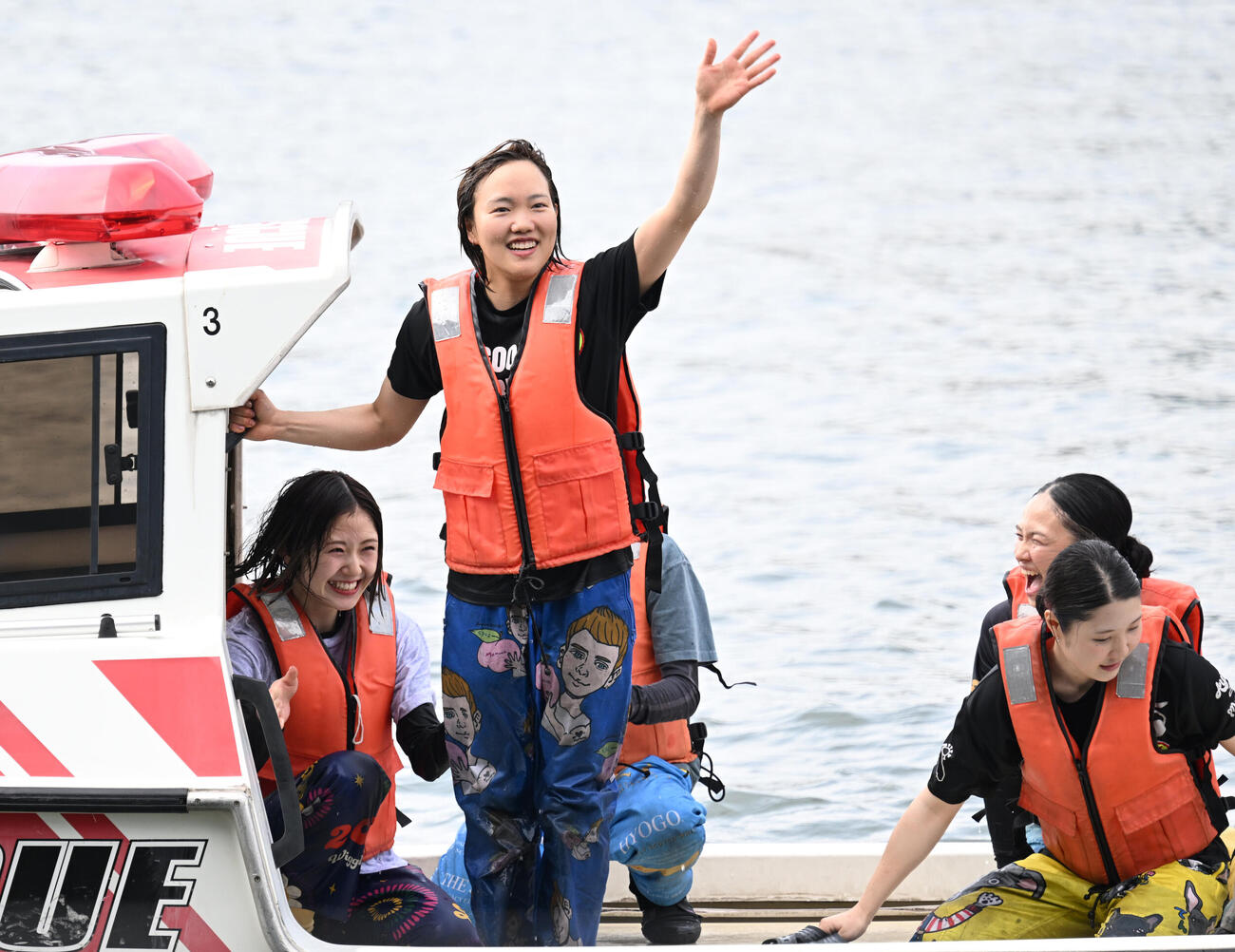 初勝利を挙げ、水神祭に向かう船上からファンに手を振り歓声に応える原村百那（撮影・千葉一成）