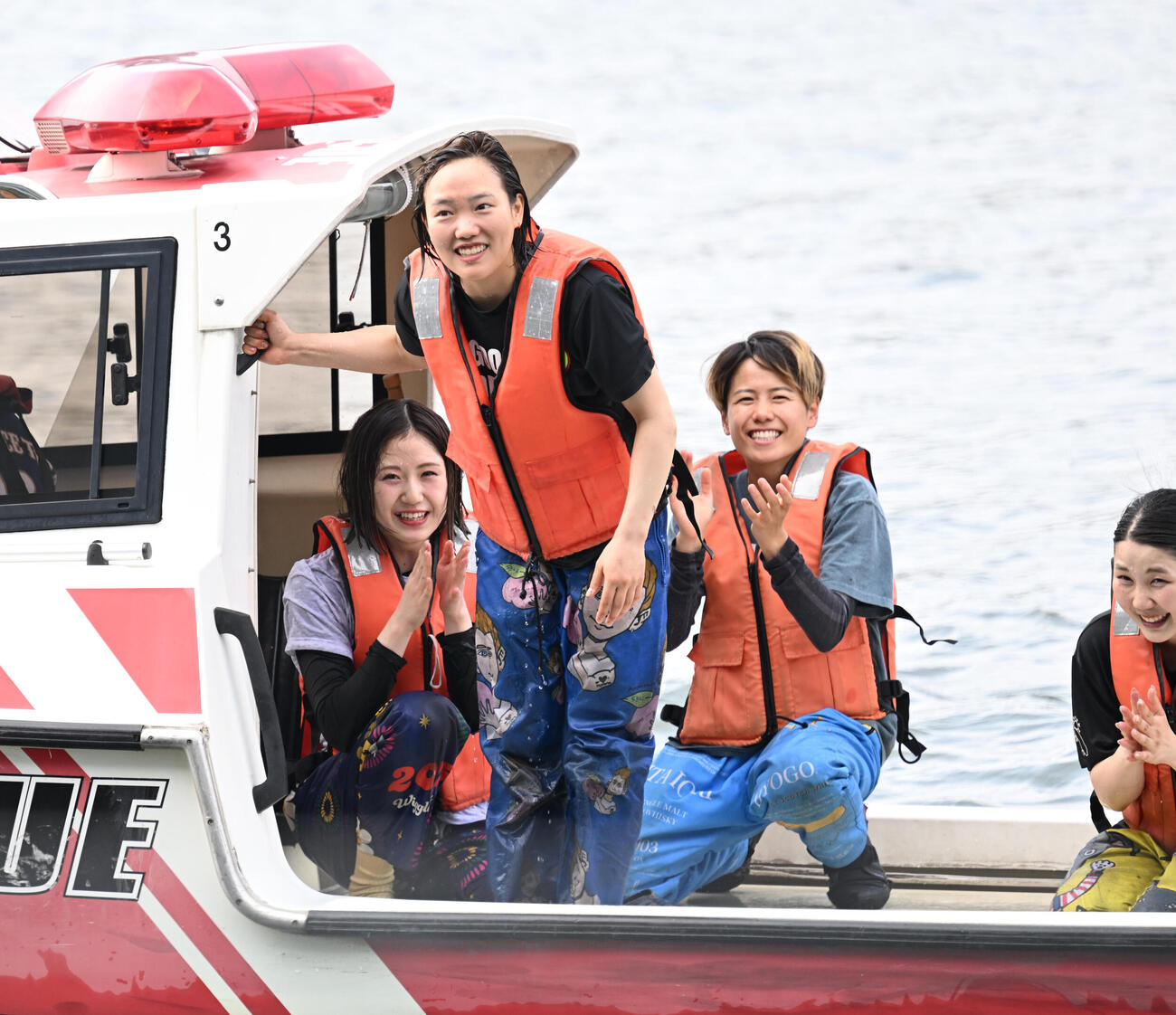 初勝利を挙げ、水神祭に向かう船上からファンに手を振り歓声に応える原村百那（撮影・千葉一成）