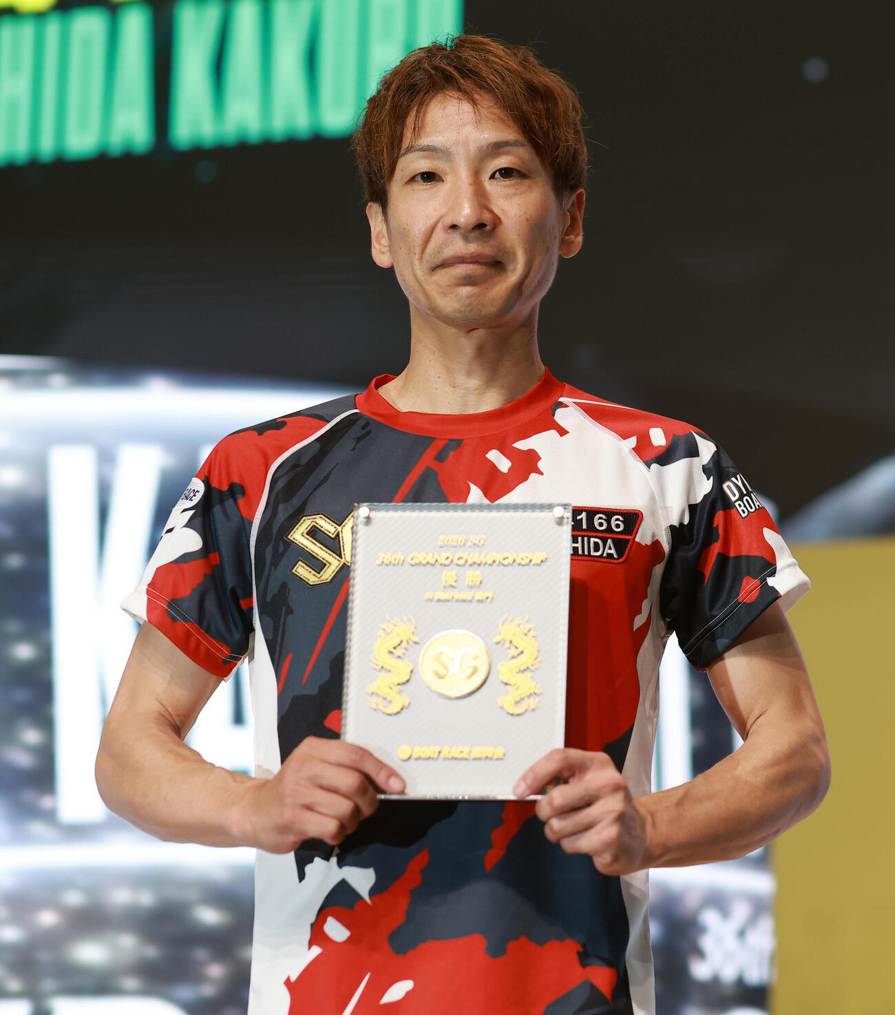 メダル入り記念盾を手にする吉田拡郎
