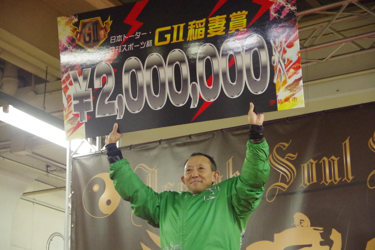 優勝して賞金ボードを掲げる若井友和