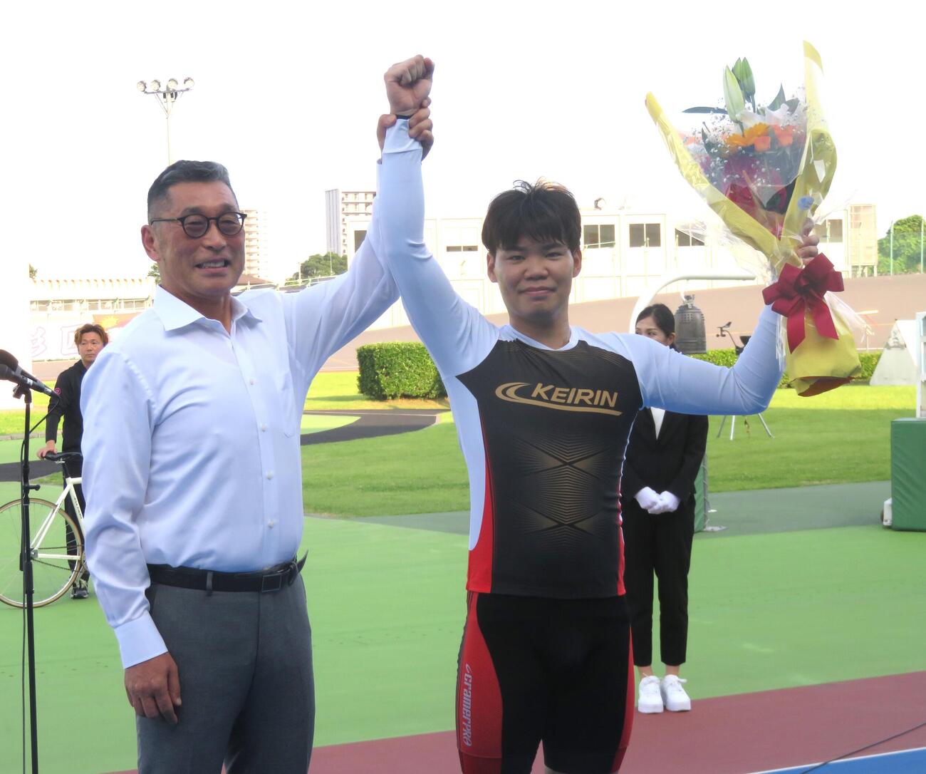 日本競輪選手養成所アドバイザーの滝沢正光氏（左）に祝福される吉田拓矢