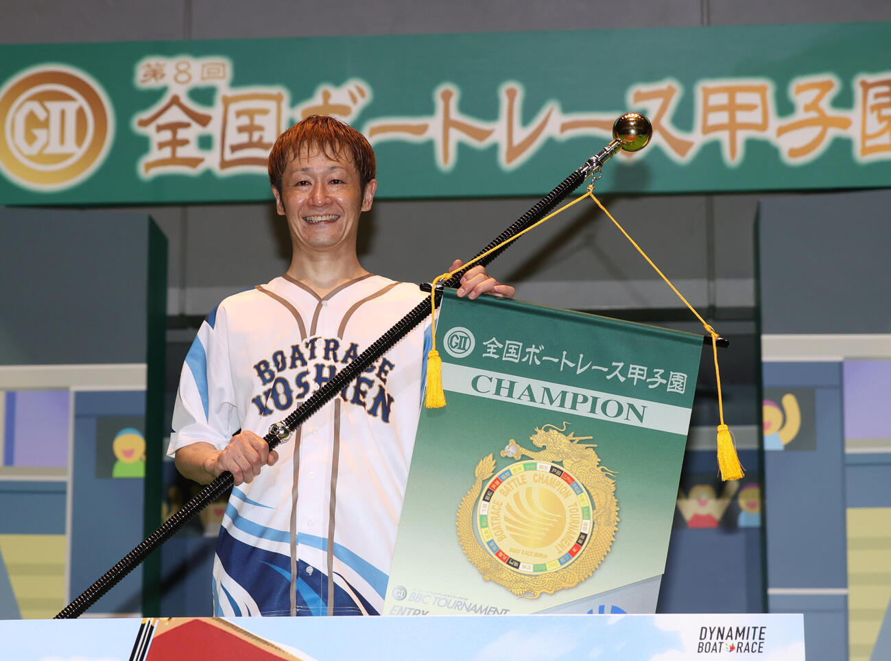 チャンピオンフラッグを持ち記念撮影に納まる大峯豊（撮影・柴田隆二）