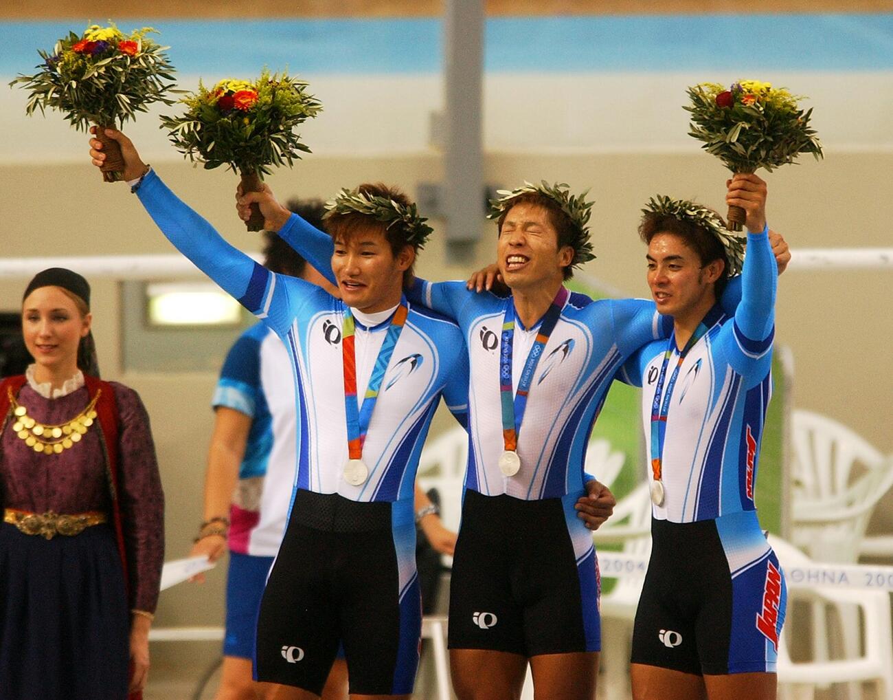 アテネ五輪・自転車男子チームスプリント決勝　表彰台で銀メダルを胸にする日本チーム。左から長塚智広、伏見俊昭、井上昌己（2004年8月撮影）