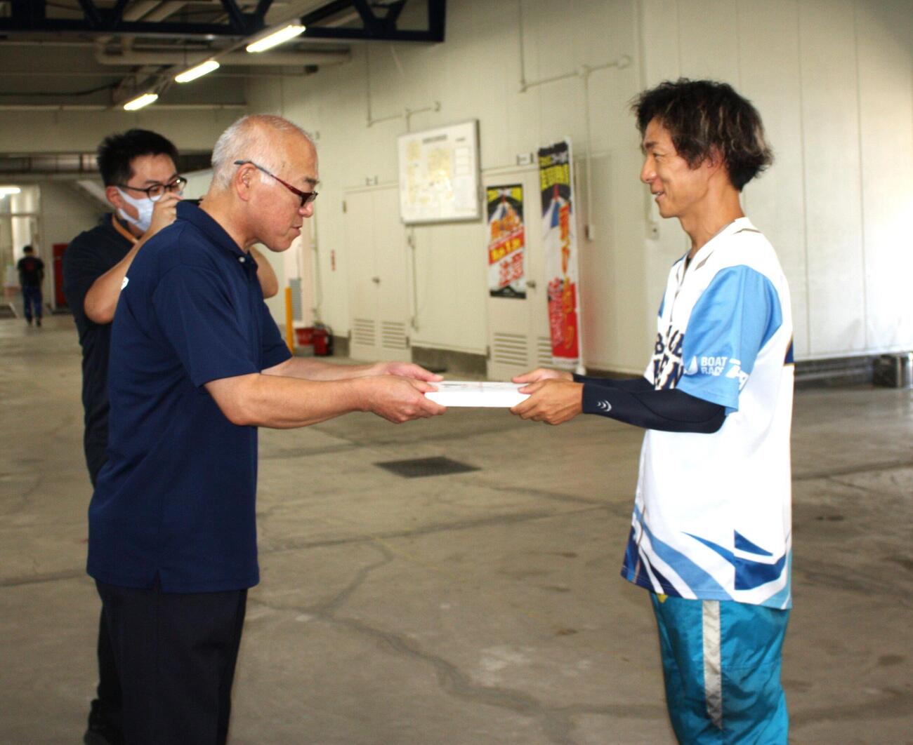 初日1Rで10連勝を達成。事業局長からお祝いの商品を受け取る松田祐季